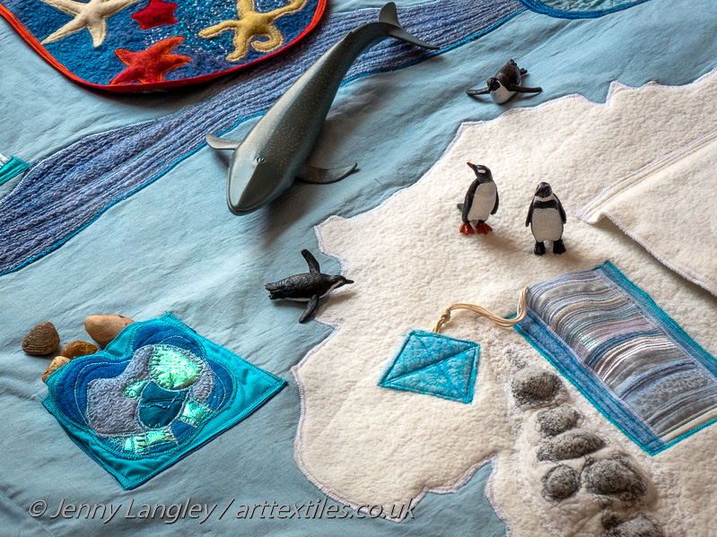 Whale and penguin models on the mat.