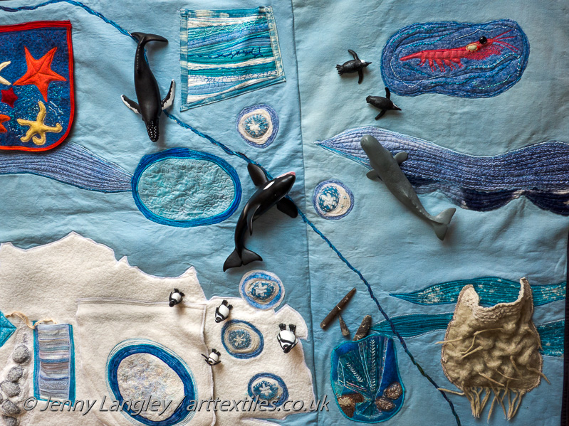 Whale and penguin models on the mat.