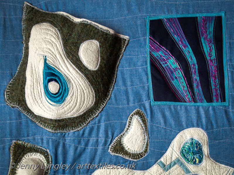 Pocket with islands and meltwater lake and lined with sheepskin.  Panel showing Aurora Borealis or Northern Lights, with background fabric which is noisy when scratched.