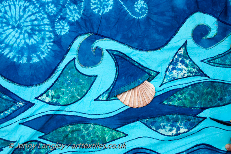 A shell peeping out of a pocket in the sea.
